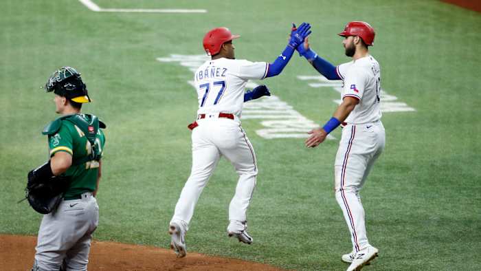 Jun 21, 2021; Arlington, Texas, USA; Texas Rangers second baseman Andy Ibanez (77) is congratulated by right fielder Joey Gallo (13) after hitting a three run home run in the first inning against the Oakland Athletics at Globe Life Field.